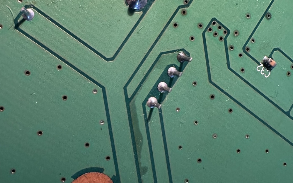 この写真も基板裏側で電解液がパターンを侵食している。これはちょうどDCDCコンバータの真下