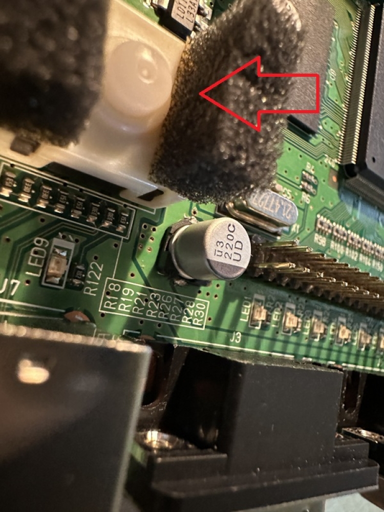基板左側手前のコンデンサも新しいものをはんだ付けする。ただこれすごく狭くてはんだ付けしにくいので、電源ボタンを一旦外して（スルーホールのはんだを外す）から取り付け、その後元に戻しています。